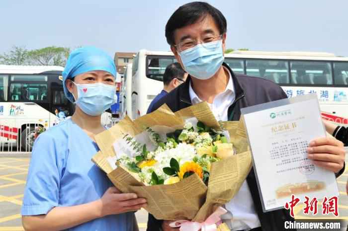 武汉同济医院医务人员给王辰院士送鲜花 王康荣 摄  中日友好医院援鄂医疗队返程 被授“同济医院职工”