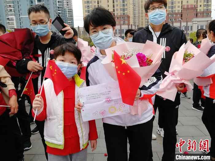 图为3月21日张静静跟随医疗队从黄冈返程时,手里拿着当地小朋友送给她的一幅画。山东大学齐鲁医院供图  援鄂护师张静静去世 国家卫健委:人民会感激和怀念她