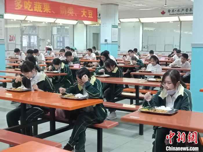 海南枫叶国际学校学生就餐相隔一米以上,实行专人专座,且只能单向就坐。 张茜翼 摄  海南高三、初三开学 单人单桌上课错时就餐